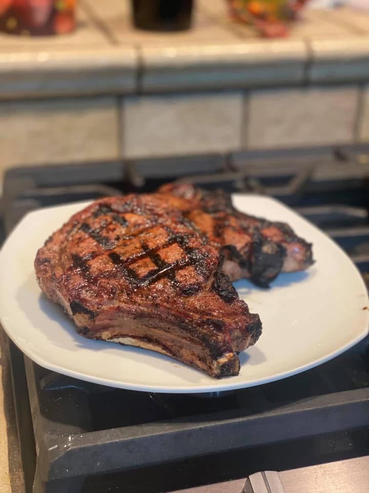 A grilled steak on a white plate.